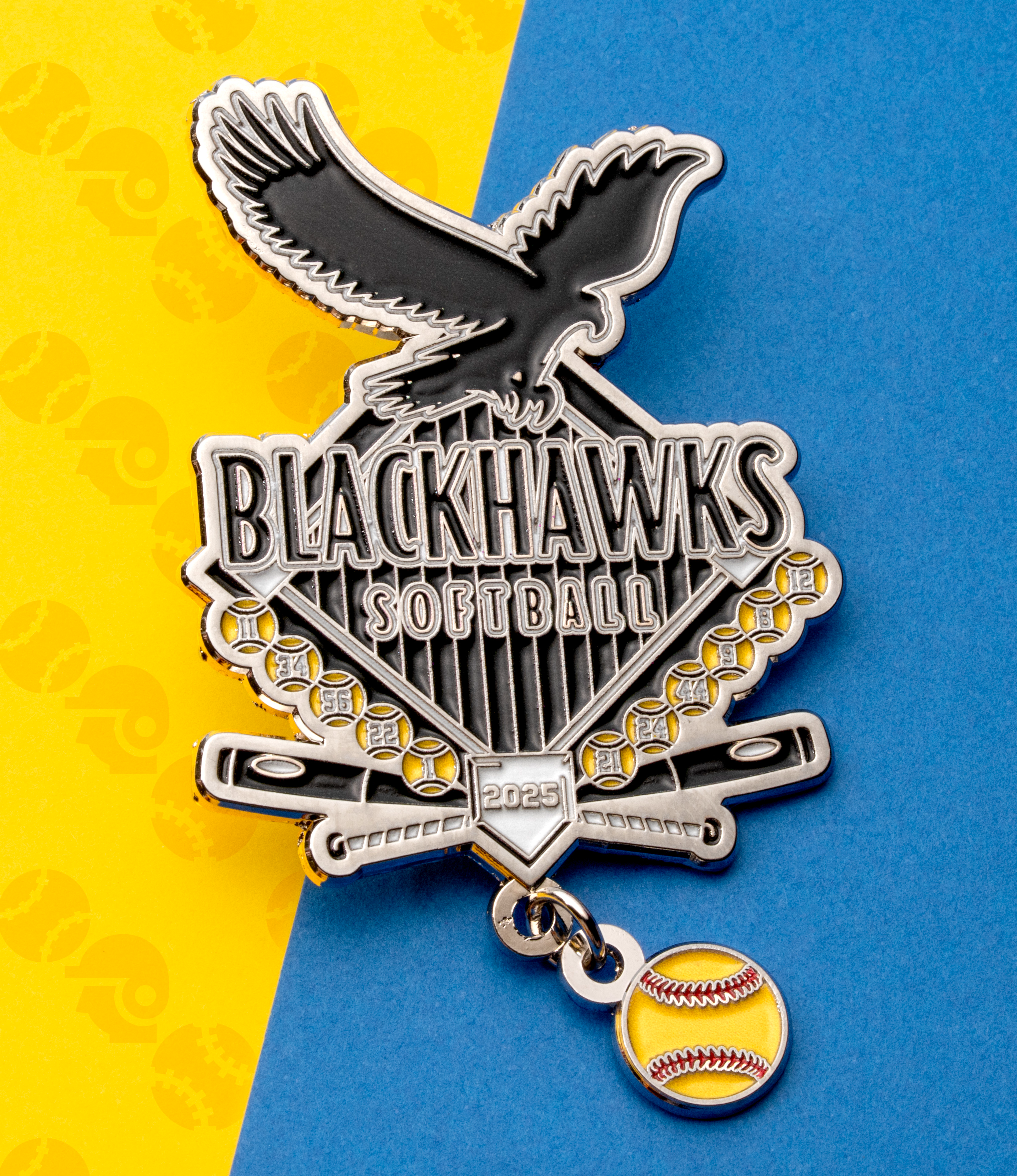 Soft enamel lapel pin for Blackhawks Softball featuring an eagle, baseball diamond, bats, and a dangling yellow softball charm.