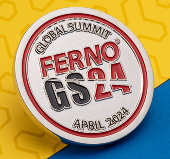Circular lapel pin for the Ferno Global Summit GS24 featuring red and black text on a silver background with a red border.