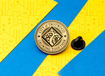 Circular gold City of Trotwood lapel pin featuring a stylized tree emblem and the text Growing Together.