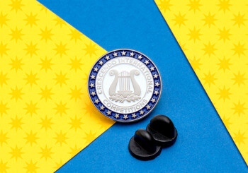 Circular lapel pin for Crescendo International Competitions featuring a silver lyre icon on a white background with a blue star border.