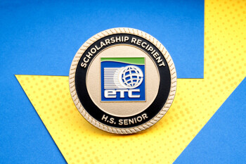 Gold challenge coin for an ETC Scholarship Recipient H.S. Senior featuring a blue globe logo and rope edge.